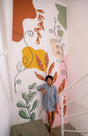 Large abstract botanical wall decal with colorful shapes and flowing lines applied to a staircase wall.