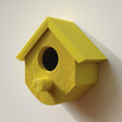3D printed birdhouse with round entrance and cylindrical perch made of matte PLA plastic.