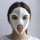 Adult person wearing a smooth white 3D printed futuristic mask with anime-style cutouts and two downward points.