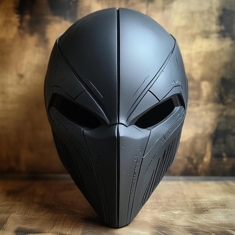 Close-up of a matte black 3D printed warrior mask with angular cheek panels and narrow eye openings.