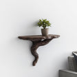 A brown 3D printed wall shelf shaped like a twisted tree root.