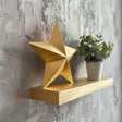 3D printed star-shaped wall shelf in matte gold finish with geometric design.