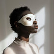 Adult person wearing a minimalist white 3D printed eye mask.