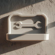 3D printed wall-mounted tool shelf with a shallow tray and embossed wrench icon.