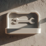 3D printed wall-mounted tool shelf with a shallow tray and embossed wrench icon.