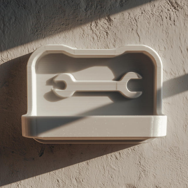 3D printed wall-mounted tool shelf with a shallow tray and embossed wrench icon.