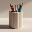 Cream-colored cylindrical 3D printed pencil holder with vertical ribbed grooves.