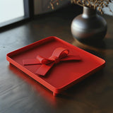 3D printed gift bow trinket tray with ribbon-shaped handle and a matte PLA finish.