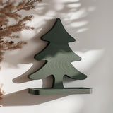 3D printed green wall shelf shaped like a minimalist Christmas tree silhouette with a small ledge.