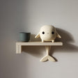 3D printed wall shelf with a small whale character on the ledge and a tail fin support beneath.