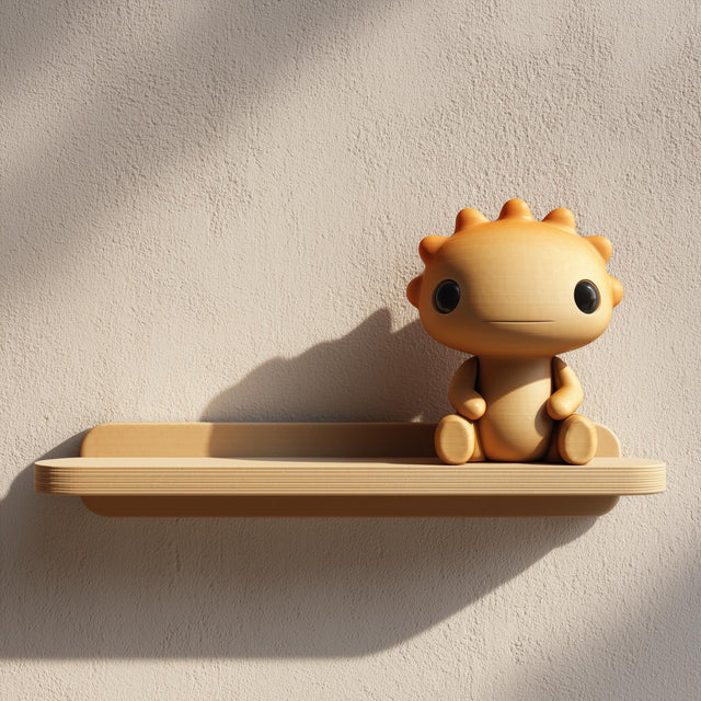 3D printed wall shelf with a small sun-like character sitting on a slim tray-style ledge.