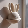 3D printed wall decor shaped like a bunny head with long ears and a small semicircular pocket below.