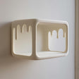 Open rectangular 3D printed wall shelf with dripping cutout edges made of matte PLA plastic.