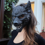 Woman wearing a detailed black 3D printed werewolf mask with sharp teeth and pointed ears, posing outdoors in a dark outfit.