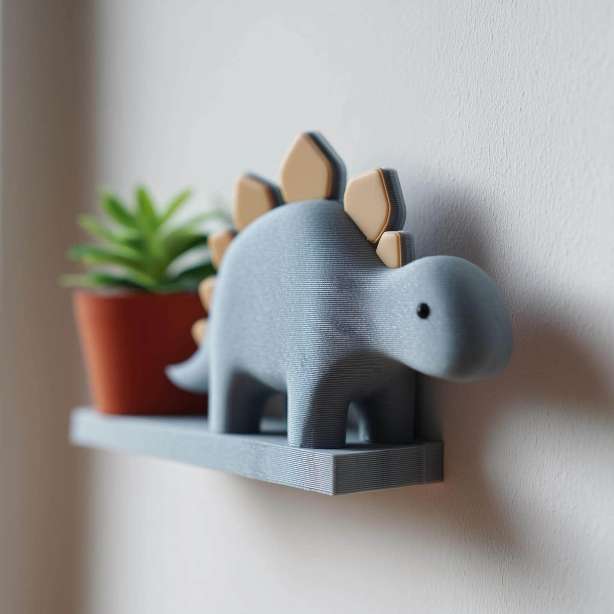 3D printed wall shelf shaped like a cute stegosaurus with a small ledge, holding a plant pot.
