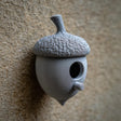 3D printed acorn-shaped birdhouse with round entrance and small cylindrical perch made of matte PLA plastic.