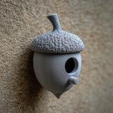 3D printed acorn-shaped birdhouse with round entrance and small cylindrical perch made of matte PLA plastic.