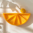 3D printed wall shelf shaped like a citrus slice.