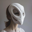 3D printed futuristic alien mask in matte white, worn by an adult model indoors.