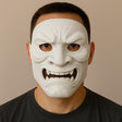 Man wearing a full-face white 3D printed Oni mask with sharp fangs and intense expression.