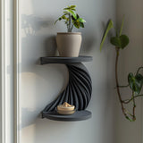 3D printed double-tier spiral wall shelf in matte dark PLA, with a twisting ribbed support between two round shelves.