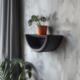 Half-circle 3D printed wall shelf with a curved frame and small plant display.