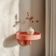 Circular-frame 3D printed wall shelf with a compact ledge holding a vase.