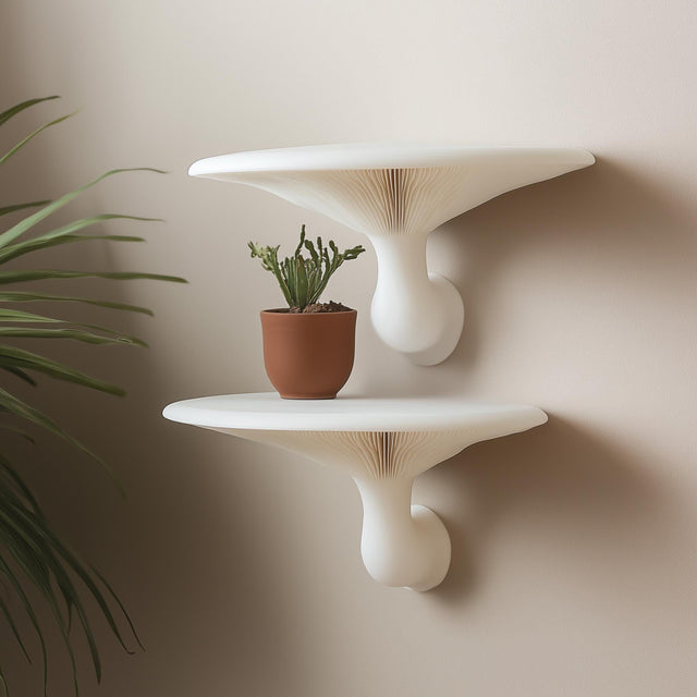 Pair of white 3D printed mushroom-inspired wall shelves mounted on a neutral wall, styled with a terracotta potted cactus.