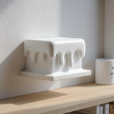 3D printed melting wall shelf with rounded dripping edges beneath a rectangular ledge.