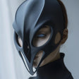 3D printed futuristic mask with gothic sculptural shape, worn by an adult model indoors.
