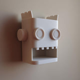 White 3D printed robot head wall organizer with an open mouth storage niche.