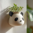 3D printed wall-mounted planter shaped like a cute panda head in matte speckled PLA.