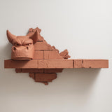3D printed wall shelf with a stylized dragon head emerging from a cracked brick backdrop.