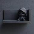 3D-печатная полка с маленькой фигурой в капюшоне.