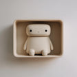 3D printed matte PLA wall niche with a rounded rectangular shelf and an integrated sitting character figure.
