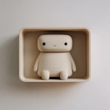 3D printed matte PLA wall niche with a rounded rectangular shelf and an integrated sitting character figure.