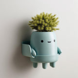 3D printed matte PLA wall planter shaped like a cute character with little legs.
