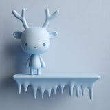 3D printed wall shelf with a smooth icicle-edge ledge and a small antlered character standing on top.