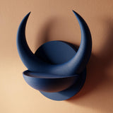3D printed matte PLA wall shelf shaped like a round plaque with two large crescent horns forming a small bowl.