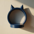 3D printed matte PLA wall shelf shaped like a round ring with small cat ears on top, in a solid dark blue color.