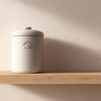 Minimalist 3D printed pet cremation urn with subtle paw print detail.