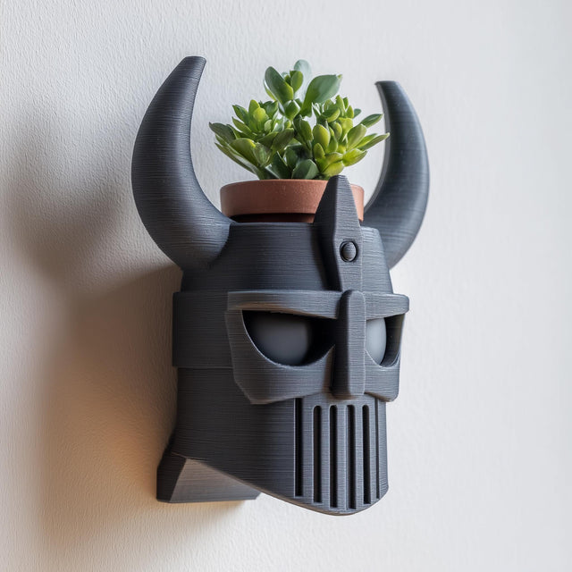 3D printed wall mounted Viking helmet planter shelf in matte dark PLA with horned helmet design and small plant pot.