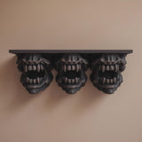 3D printed dark monster wall shelf with three snarling creature heads featuring open mouths and sharp teeth.