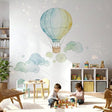 Watercolor wall decal of a single hot air balloon in light blue and pale yellow floating against a clean background.