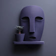 3D printed abstract face wall shelf holding a separate small plant pot