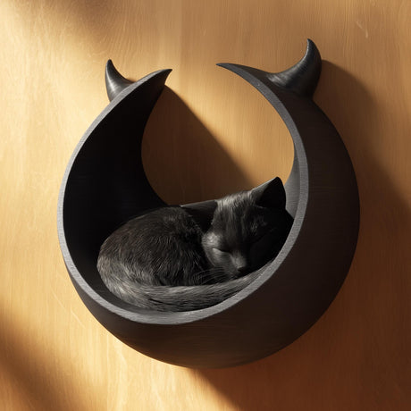 3D printed dark fantasy crescent moon wall mounted cat bed in matte black PLA with a sleeping grey cat inside.