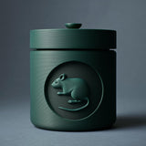 3D printed minimalist cylindrical pet ashes urn with a raised mouse medallion on the front and a fitted lidded top.
