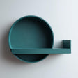 3D printed round wall shelf with a circular tray backplate and a slim floating ledge featuring a small side stopper.