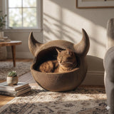 Horned floor cat cave bed with a rounded enclosed pod shape and two curved horn accents and textured surface.
