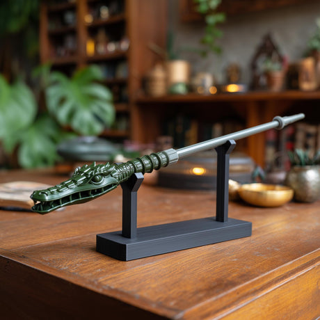 3D printed dragon crocodile magic wand with display stand on a wooden desk in a warm fantasy-inspired interior setting.